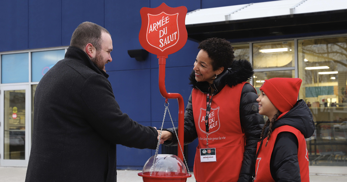 A man puts money into a Christmas kettle